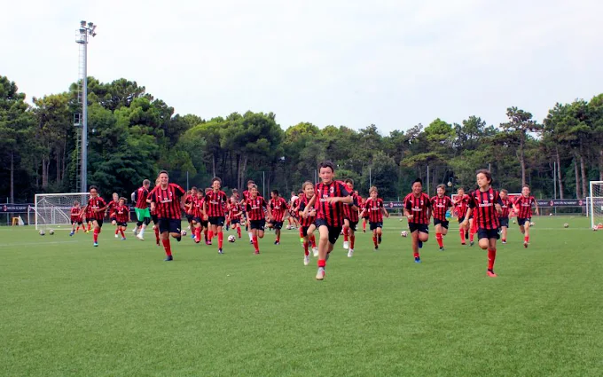 Participantes del AC Milan Academy Camp corriendo en el campo de entrenamiento en Italia